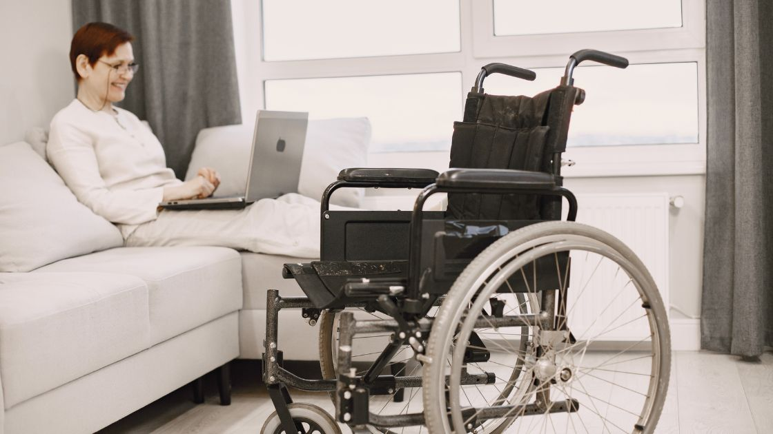 A person in a wheelchair with a laptop, representing applying for long term disability