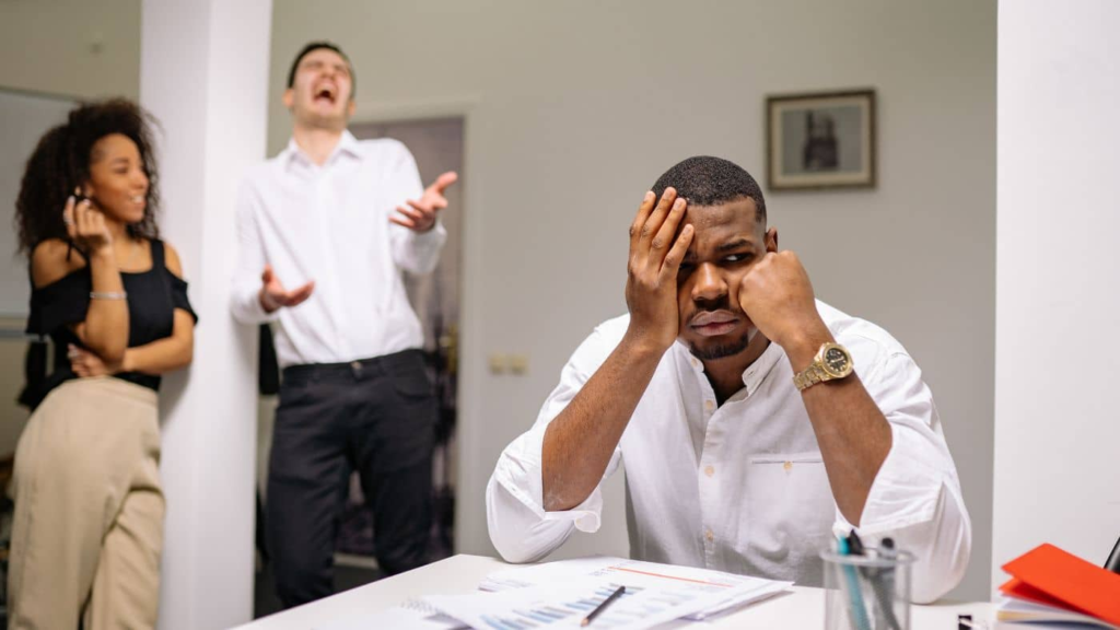 A person feeling overwhelmed by workplace bullying and harassment