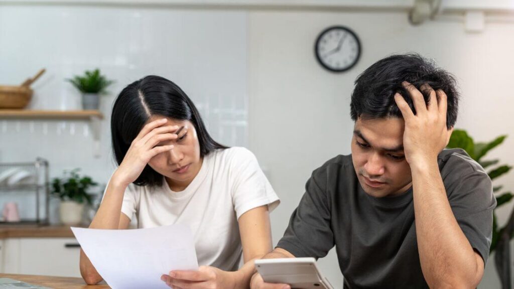 A person looking at a document with a concerned expression, representing someone considering a wrongful dismissal claim