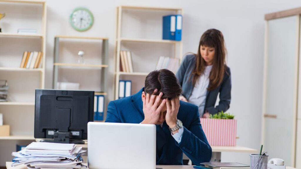 A person in distress at work, representing someone filing a claim or lawsuit for wrongful dismissal