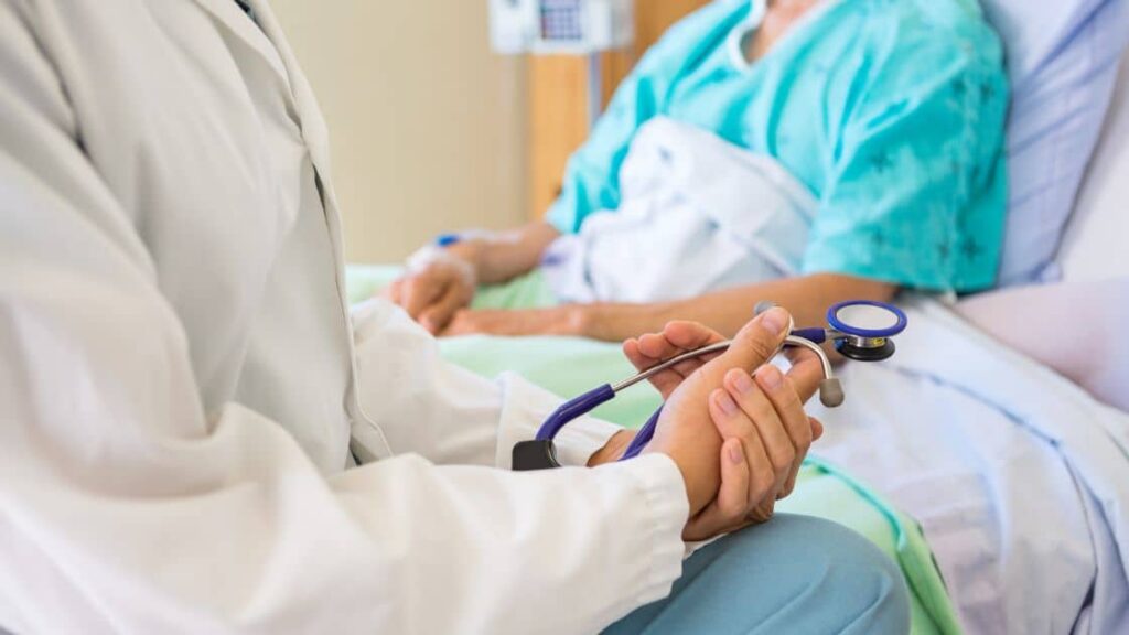 A picture of a person in a hospital bed, with a doctor and a lawyer discussing a personal injury case