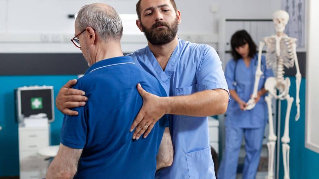 A medical professional helping a patient with back injuries