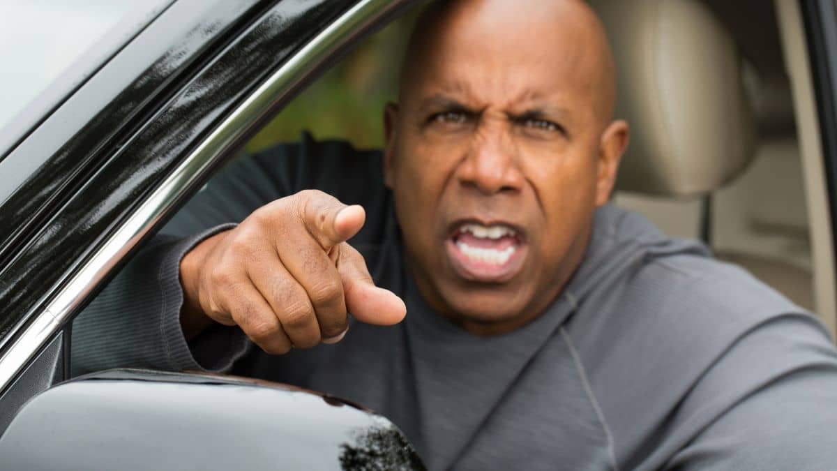 An angry driver pointing at others indicating road rage behaviour.